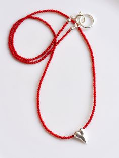 "Long Red Coral Beads Necklace, adorned with a dainty Solid Silver Sculptural Heart Charm. The necklace's versatility allows it to complement a wide range of outfits with ease, while the contrasting hues of the red coral beads and silver heart charm create a stunning focal point. The sculptural design of the silver heart adds a touch of sophistication and elegance to the piece. This necklace is a must-have in your jewelry collection, and it makes the perfect gift for your loved one. THE STORY AB Cheap Red Beaded Necklace With Heart Beads, Red Heart Beads Pendant Jewelry, Red Beaded Necklaces With Heart Beads, Red Heart Beads Jewelry For Valentine's Day, Adjustable Heart-shaped Beaded Necklace With Tiny Beads, Red Adjustable Necklace With Heart Beads, Red Heart Necklace With Lobster Clasp, Silver Beaded Necklaces With Heart Beads For Gift, Silver Beaded Necklace With Heart Charm As Gift