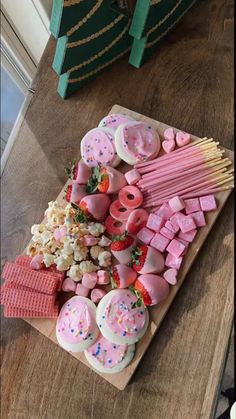 a wooden table topped with lots of candy and marshmallows on top of it