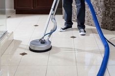 a man is using a vacuum to clean the floor