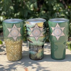 three police cups sitting on top of a cement ground