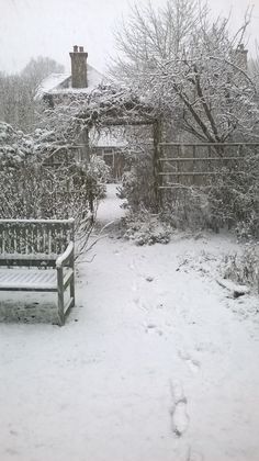 a bench sitting in the middle of a snow covered yard