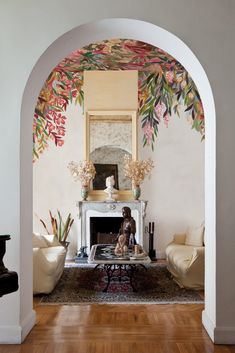 a living room filled with furniture and a painting on the wall above it's fireplace