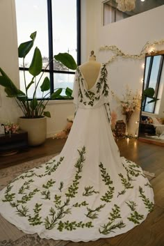 a white dress with green leaves on it