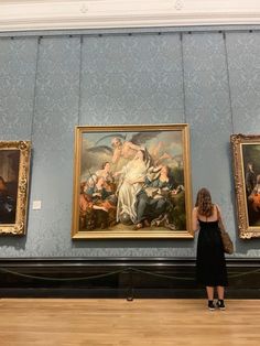 a woman standing in front of two paintings