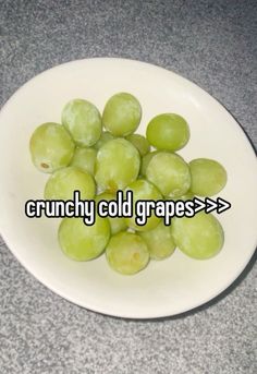 some green grapes in a white bowl on a counter top with the words crunchy cold grapes