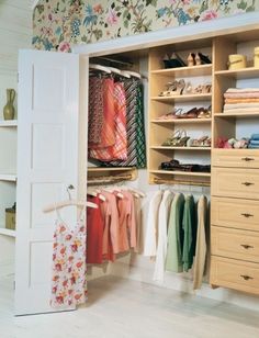 an open closet with clothes hanging on it