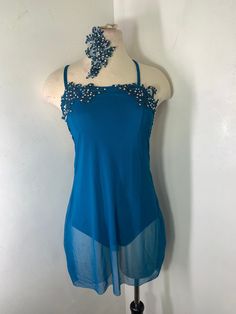 a woman's blue top with beading on the shoulders and neckline, hanging from a mannequin