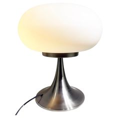 a table lamp with a white light on it's base and a cord plugged in