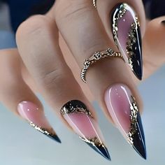 a woman's nails with gold and black designs on them