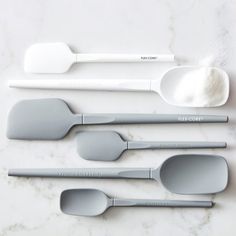 spoons and measuring spoons are laid out on a marble surface