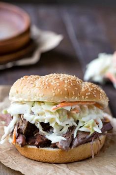 a pulled pork sandwich with coleslaw on a bun