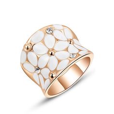 a gold ring with white flowers and crystal stones on the outside, in front of a white background