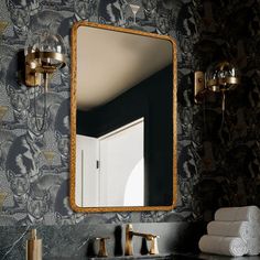 a bathroom with a mirror, sink and towels on the counter