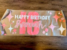 a happy birthday banner with the number ten written on it and stars in pink, orange and white