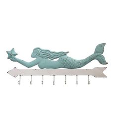 a green mermaid holding a starfish on top of a white shelf