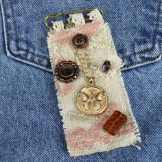 a cell phone case with buttons and chains attached to it's back pocket, sitting on a piece of fabric