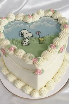 a cake shaped like a heart with a snoopy dog on the front and side