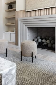 a living room with a fire place and two stools