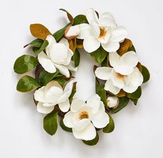 a wreath made out of white flowers and green leaves