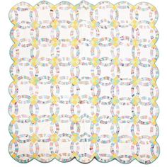 a white quilt with multicolored circles on the center and two rows of squares in the middle