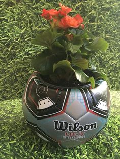a soccer ball shaped planter with flowers in it