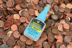 a bottle of paint sitting on top of a pile of pennets and penny coins