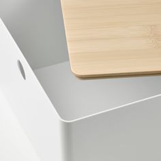 a wooden cutting board sitting on top of a white box