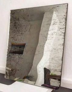 a large mirror sitting on top of a wooden table