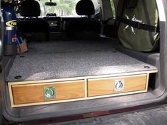 the back end of a van with its cargo compartment open and two drawers on each side