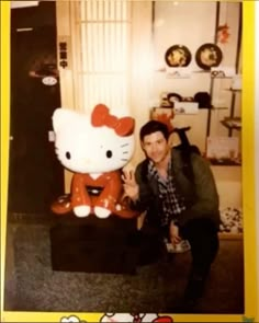 a man posing with a hello kitty statue in front of him and an image of himself