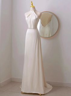 a white dress is on display in front of a mirror and a mannequin