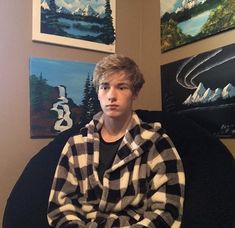 a young man sitting in a chair with his arms crossed