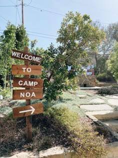 a wooden sign that says welcome to camp noa with arrows pointing in different directions