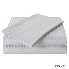 two sheets with grey and white stripes are folded on top of each other in front of a white background