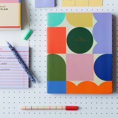 an assortment of stationery items including notebooks, pens and markers on a white surface