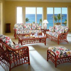 a living room filled with lots of furniture next to large windows overlooking the ocean in front of them