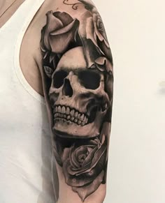 a man with a skull and roses tattoo on his arm