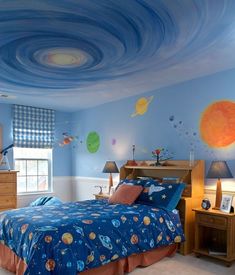 a child's bedroom decorated in blue and orange with planets painted on the ceiling