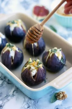 some food is in a blue dish with a wooden utensil sticking out of it