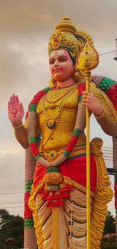 a large statue of a hindu god holding a stick