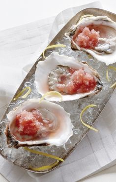 three raw oysters on an ice tray