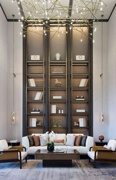 a living room filled with lots of furniture and bookshelves in front of a window