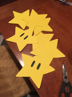 some cut out pieces of paper sitting on top of a wooden table next to scissors