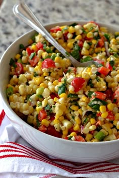 a white bowl filled with corn and vegetables