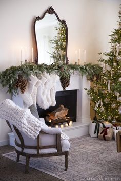 a fireplace decorated for christmas with stockings and candles