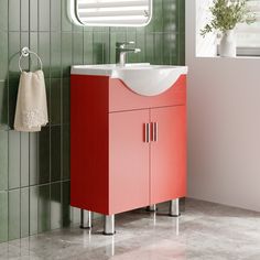 a bathroom with a sink, mirror and red cabinet in the corner next to a green tiled wall