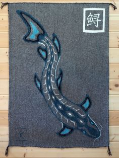 a blue and black fish on a gray background with chinese writing in the bottom right corner