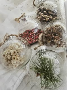 several glass ornaments with dried herbs in them