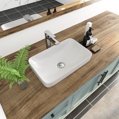 a bathroom sink sitting on top of a wooden counter next to a mirror and plant