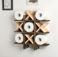 several rolls of toilet paper are stacked on top of each other in a wooden holder